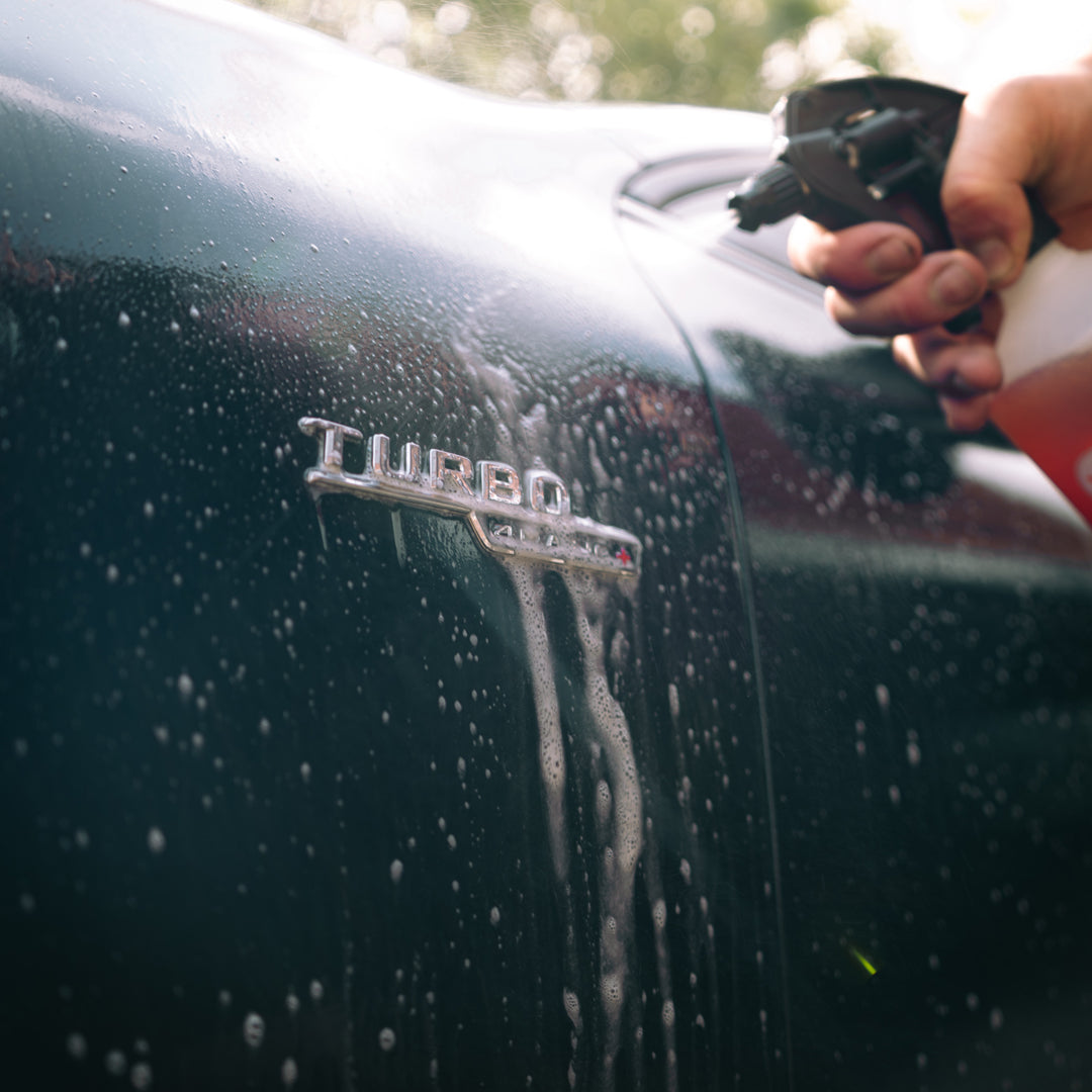 citrus pre-wash being sprayed over mercedes turbo badge