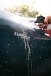 citrus pre-wash being sprayed over mercedes turbo badge